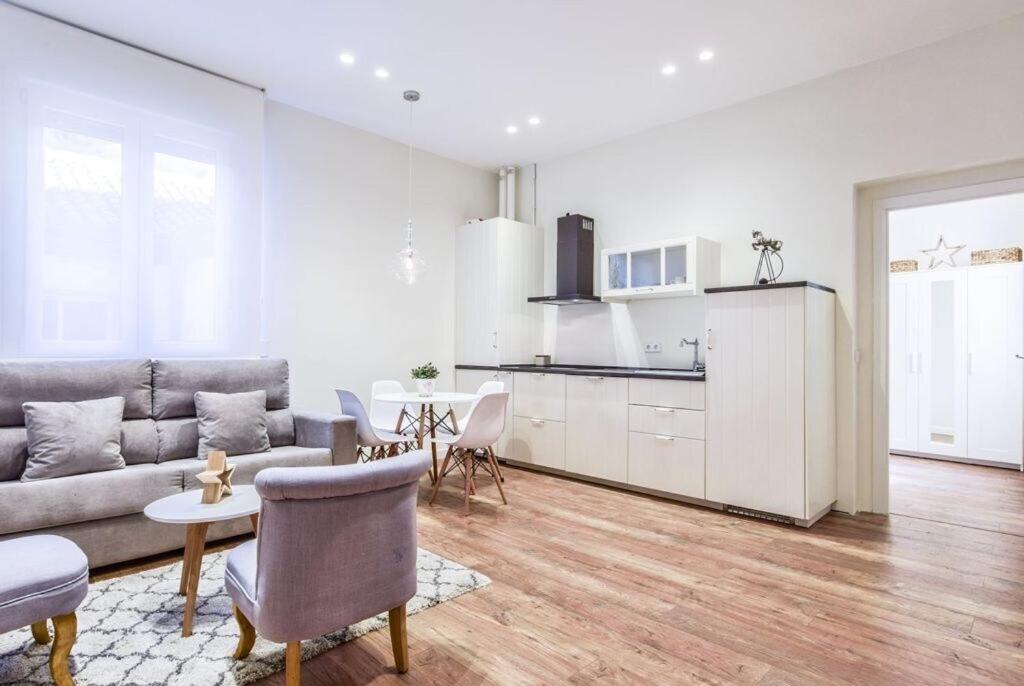 a living room with a couch and a table and a kitchen at MyHouseSpain - Estrena apartamento en el centro de Madrid - Atocha in Madrid