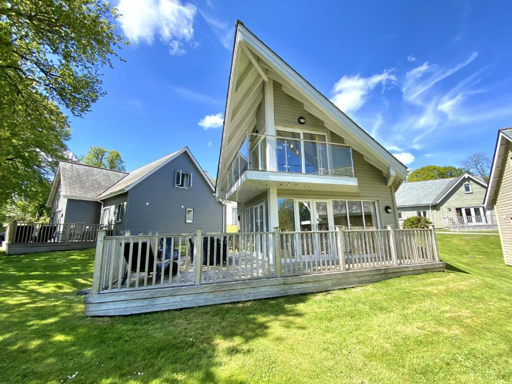 a house with a porch with a fence at Trewhiddle Retreat V25 by Together Travel - Luxury 4-Bedroom Villa in St Austell