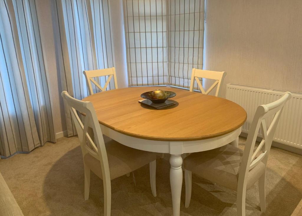 a wooden table with chairs and a bowl on it at Badgers Retreat Holiday Park in Hunton