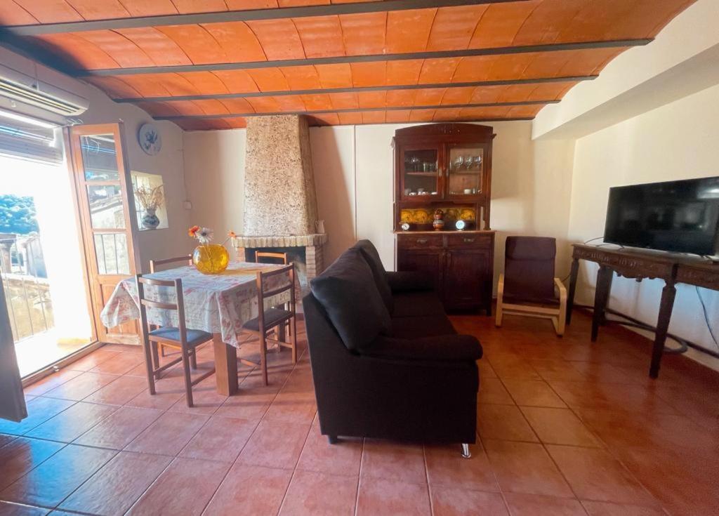 a living room with a table and a couch and a television at Casa del Bueno in Peralta de la Sal