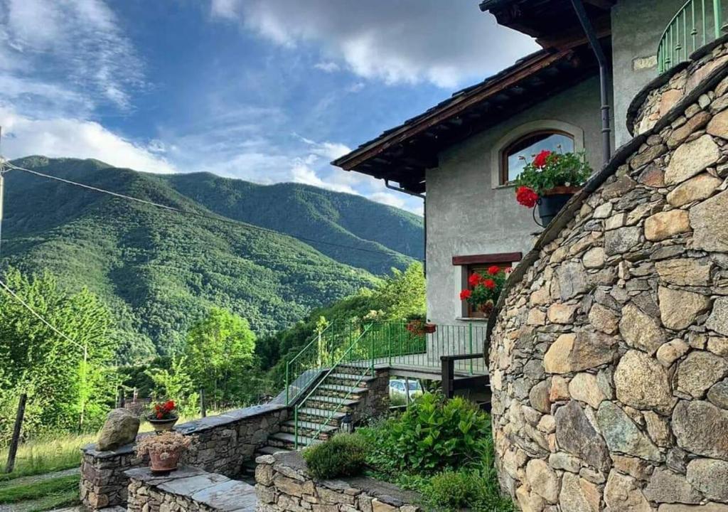 a stone building with stairs and a stone wall at L'Antica Dimora in Perosa Argentina