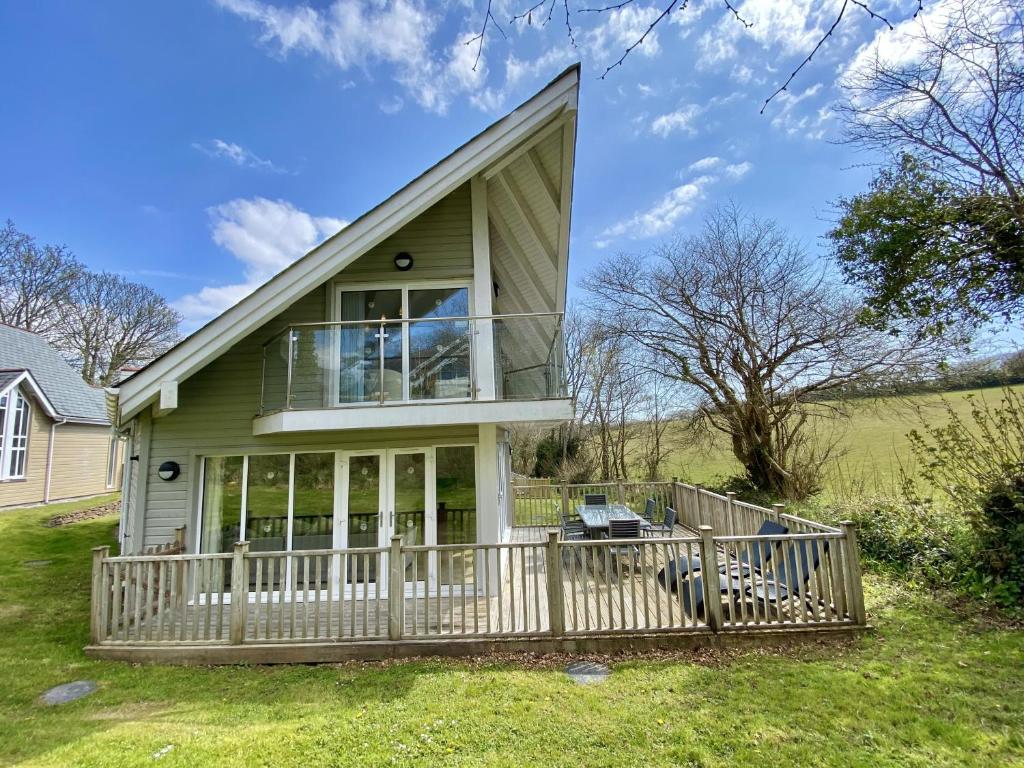 a house with a large porch with a deck at Trewhiddle Retreat V17 by Together Travel - Luxury 4-Bedroom Villa in St Austell