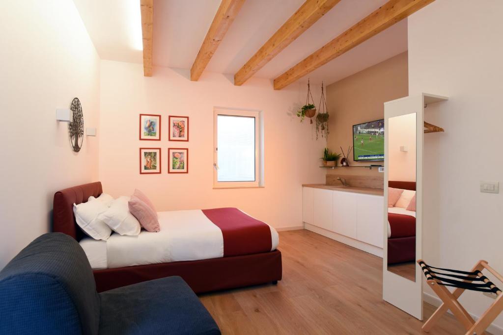 a bedroom with a bed and a living room at Maison Chene petit appartement in Bisceglie