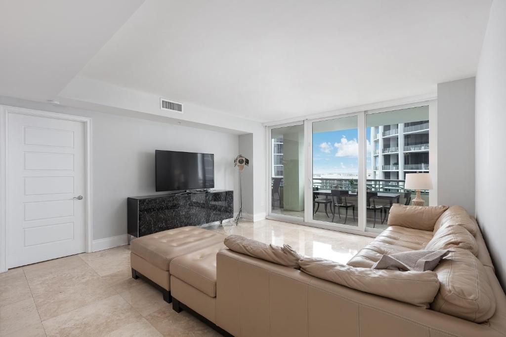 - un salon avec un canapé et une télévision dans l'établissement Ritz Carlton Coconut Grove Luxury 2 BR Apt apts, à Miami