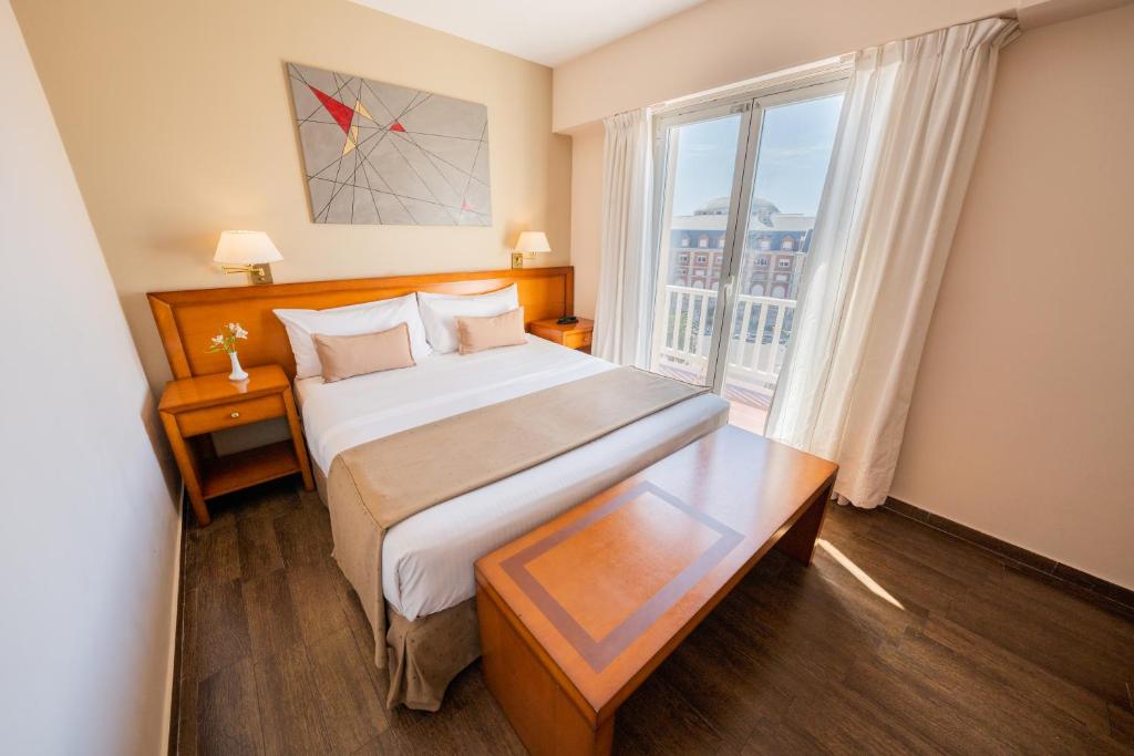 a hotel room with a bed and a large window at Hotel Riviera in Mar del Plata