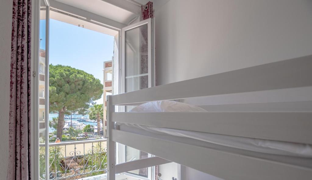 a room with a window with a view of the ocean at Hotel Les Palmiers in Sainte-Maxime