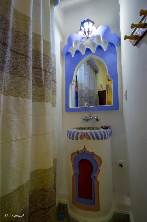 a bathroom with a sink and a mirror on a wall at Dar El Fanne in Chefchaouen