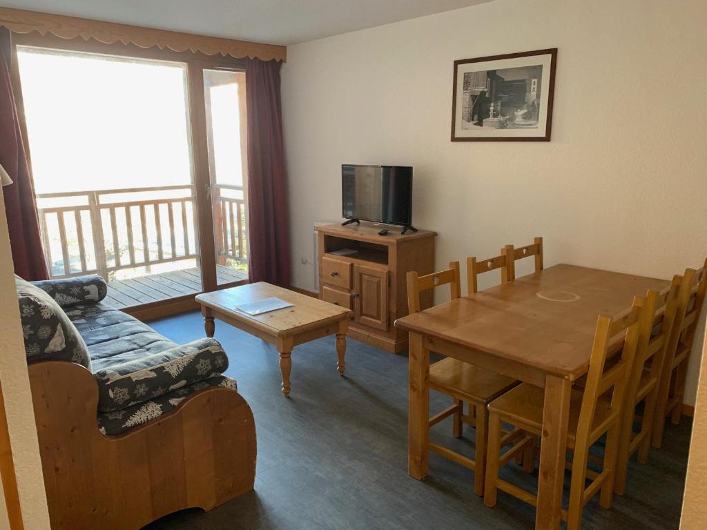 - un salon avec une table, un canapé et une télévision dans l'établissement Appartement à Orcières Merlette - 6 pers, 45m² - Proche pistes et commerces, WIFI inclus - FR-1-636-150, à Orcières