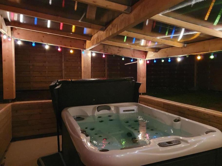 una bañera de hidromasaje en una sala al aire libre con luces en La Villa Juliette L'Etoile Filante en Biville-sur-Mer