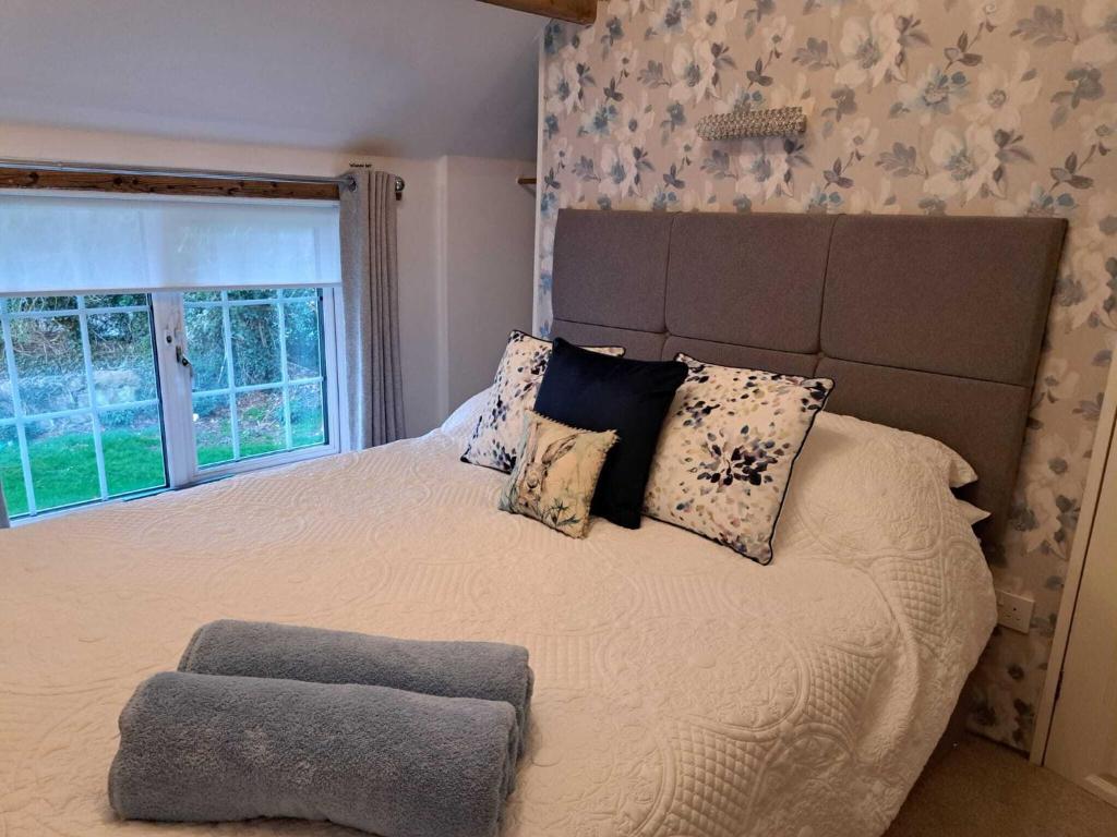 um quarto com uma cama grande e uma janela grande em Saughall Mill Farm Cottage em Chester