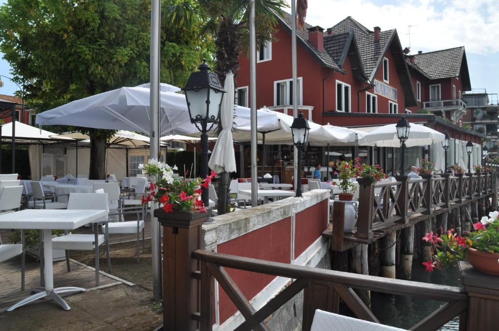 a restaurant with white tables and chairs and umbrellas at Hotel Villa Laguna in Venice-Lido