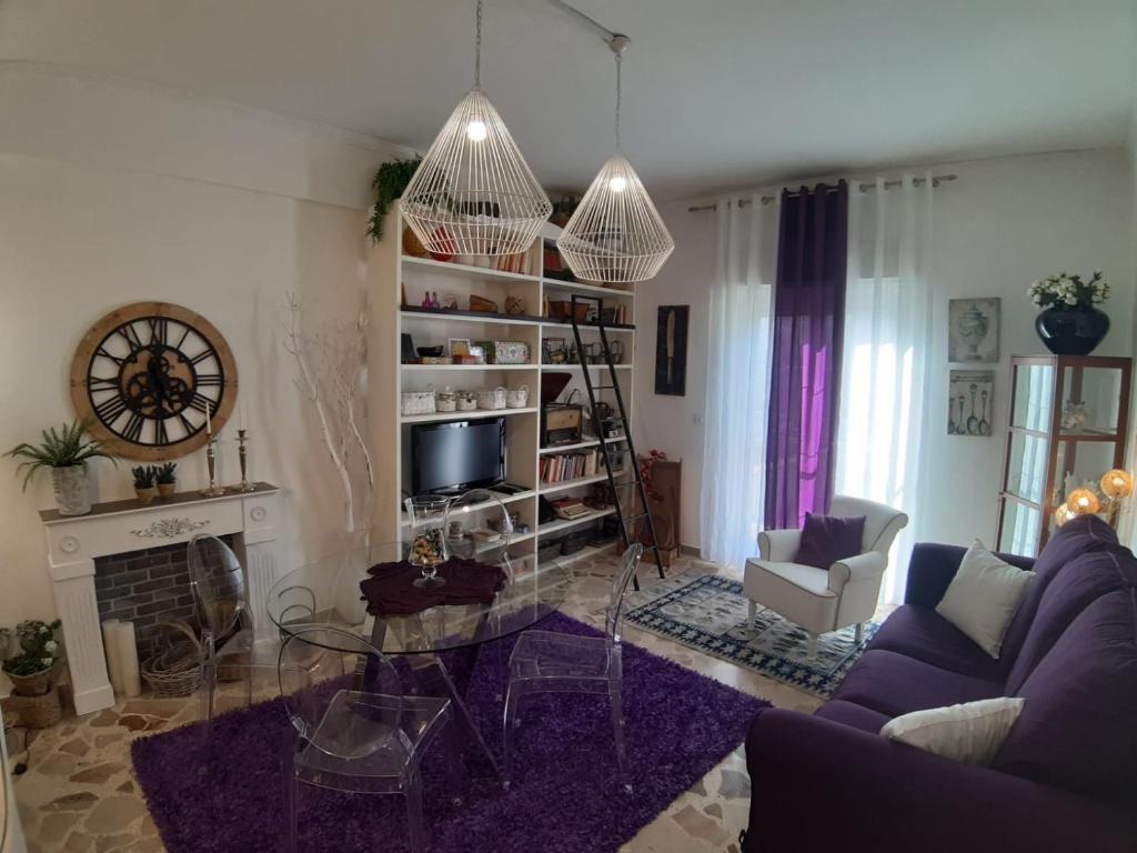 sala de estar con sofá púrpura y chimenea en Il moro di Sicilia apartment, en Termini Imerese