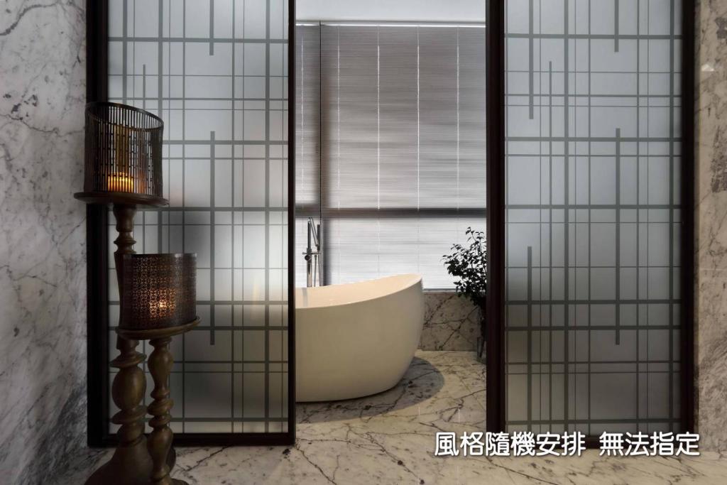 a bathroom with a bath tub and a window at Boda Hotel in Taichung