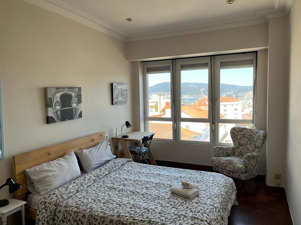 ein Schlafzimmer mit einem Bett, einem Stuhl und einem Fenster in der Unterkunft Vigo Excursions in Vigo