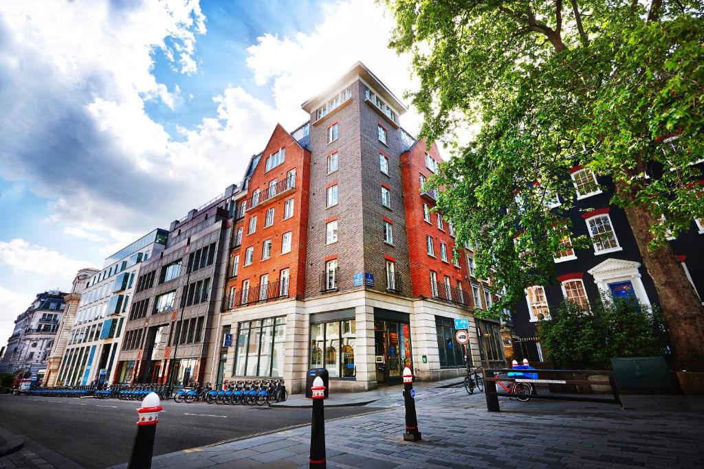 Marlin Apartments London City - Queen Street في لندن: مبنى من الطوب الطويل على شارع المدينة