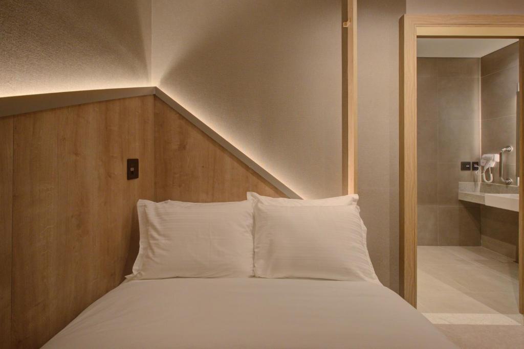Ein Bett oder Betten in einem Zimmer der Unterkunft Fast Sleep Suites by Slaviero Hoteis - Hotel dentro do Aeroporto de Guarulhos - Terminal 2 - desembarque oeste