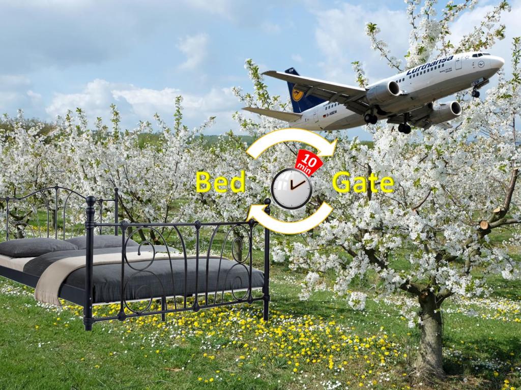 a plane is flying over a bed and a clock at VILLA ORCHARD Frankfurt in Zeilsheim