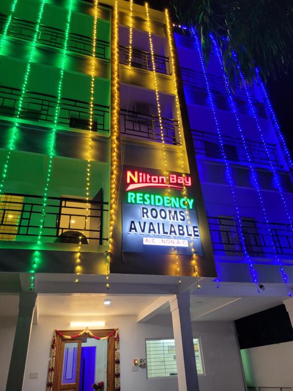 a building with green and blue lights on it at Nilton Bay Residency in Puducherry