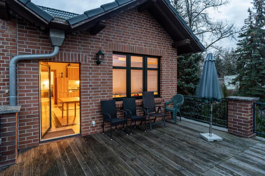un patio con mesa y sillas en una terraza de madera en Villa Landidyll mit separatem Wellness-Bereich, en Joachimsthal