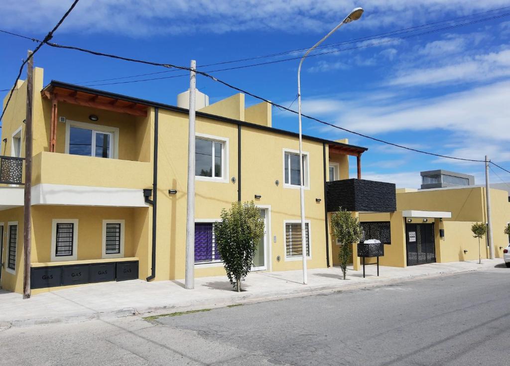 un edificio amarillo al lado de una calle en Liniers 14 en Tandil