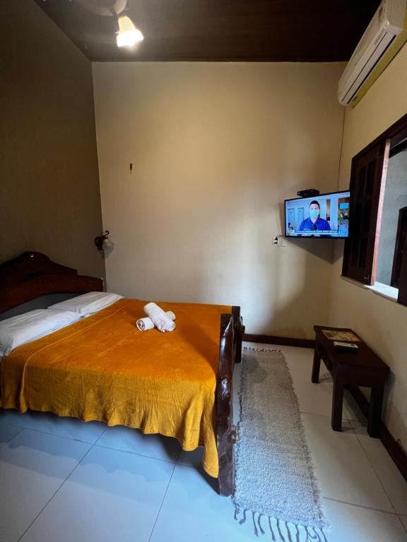 una camera con letto e TV a parete di Piratas da Vila a Jericoacoara