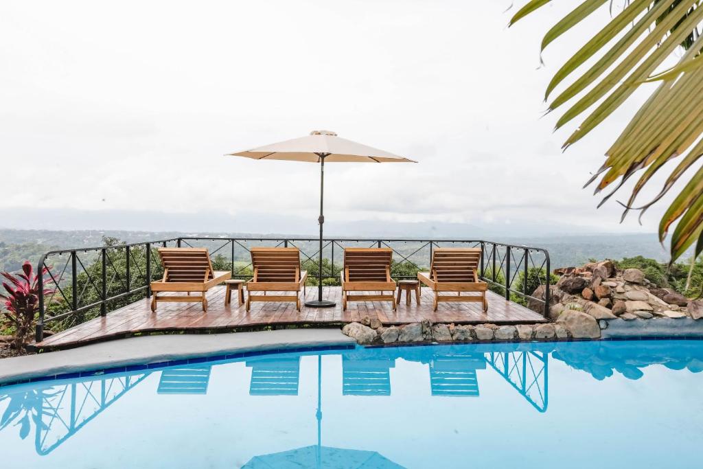 a group of chairs and an umbrella next to a swimming pool at The PAD at Buen Camino Bike Park in San Mateo