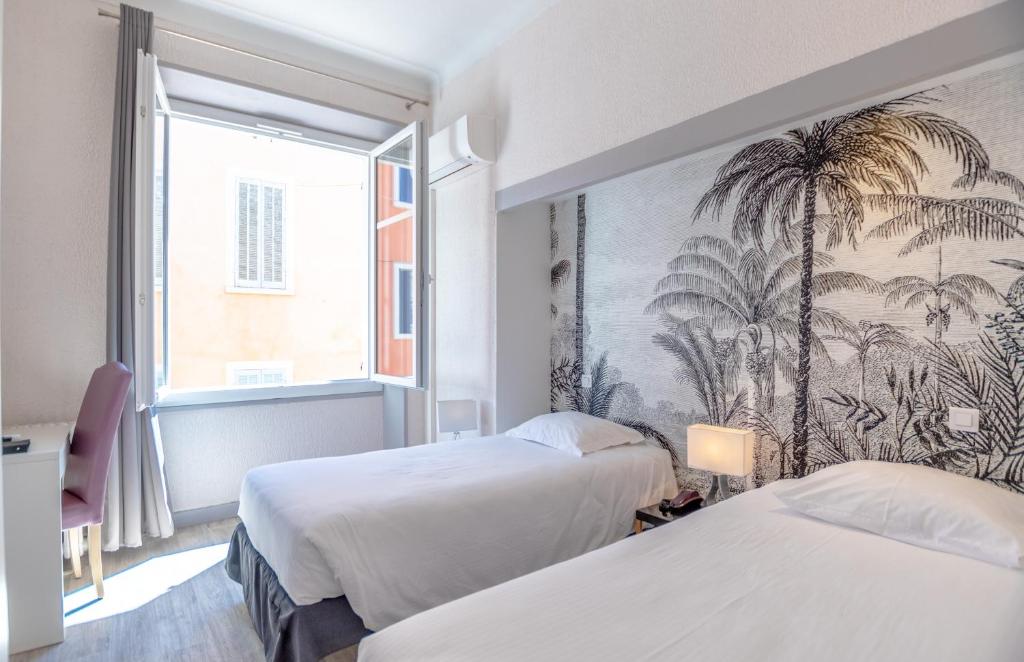 a hotel room with two beds and a mural of palm trees at Hotel Les Palmiers in Sainte-Maxime