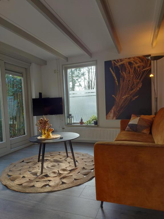 a living room with a couch and a table at de Grutto in Appelscha