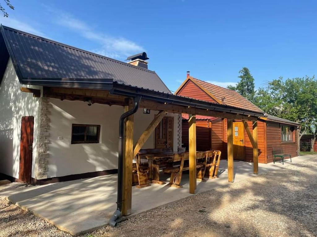 a pavilion with a table outside of a cabin at LIKe A cottage in Perušić