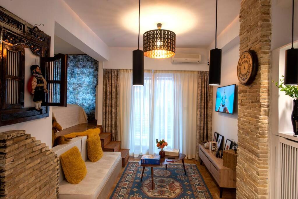 een woonkamer met een bank en een tv bij Avant-Garde Studio in Athene