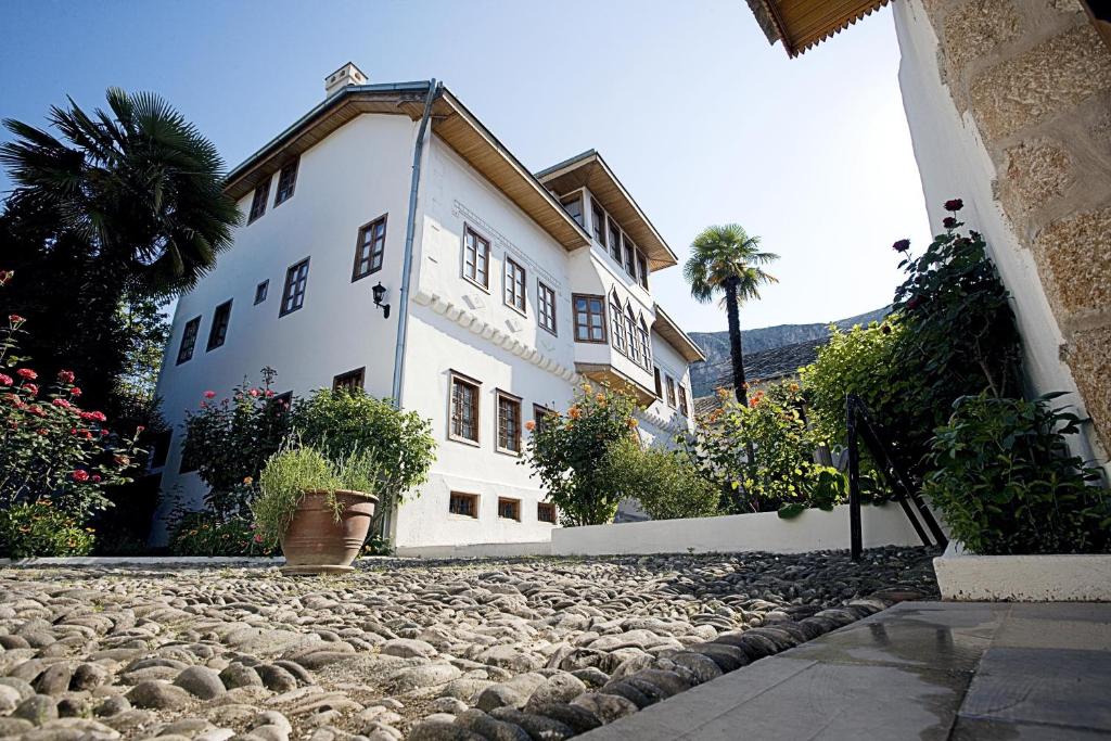 un gran edificio blanco con entrada de piedra en Bosnian National Monument Muslibegovic House, en Mostar