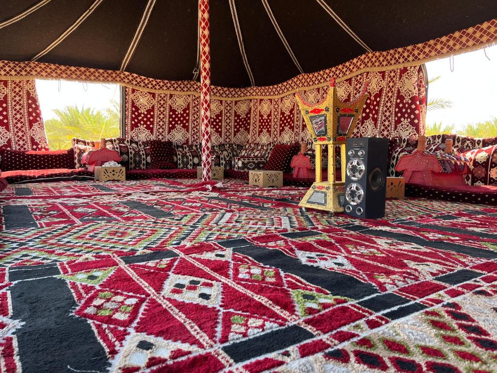 Cette grande chambre dispose d'un tapis. dans l'établissement مخيم يمك دروبي, à Al-Ula