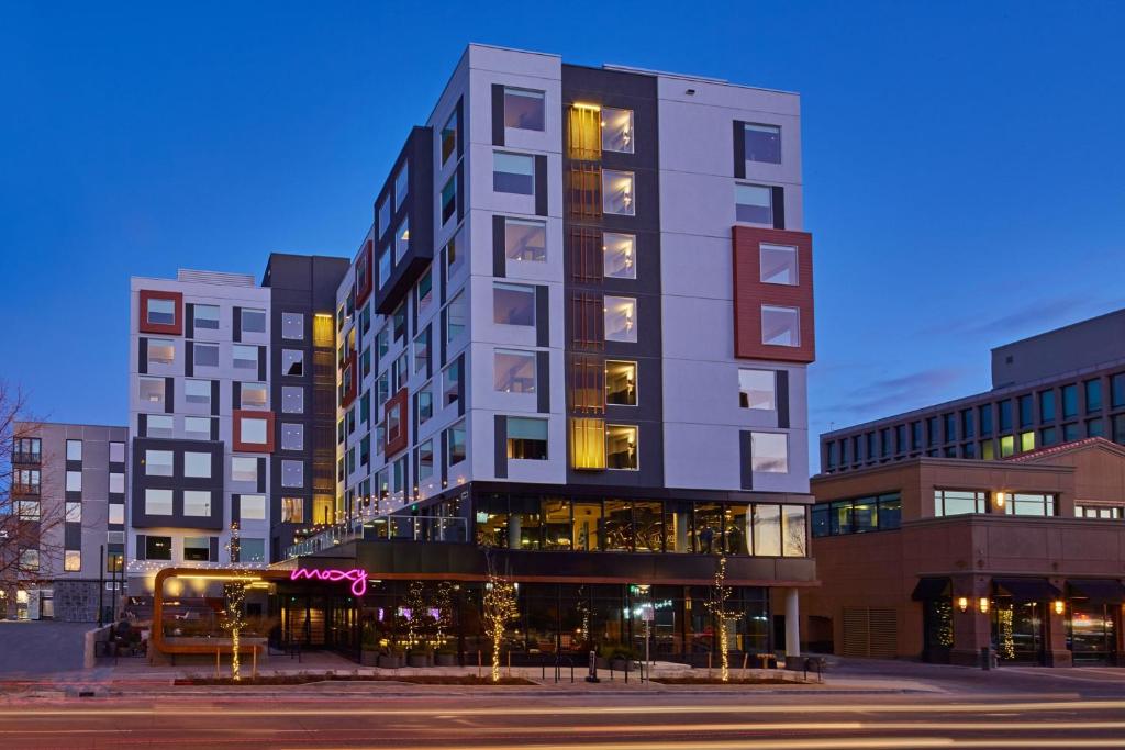 a tall building on a city street at night at MOXY Denver Cherry Creek in Denver