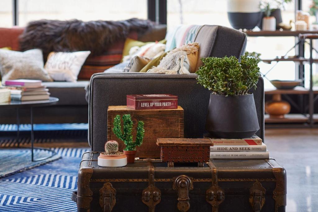 a living room with a couch and a suitcase with plants at MOXY Denver Cherry Creek in Denver