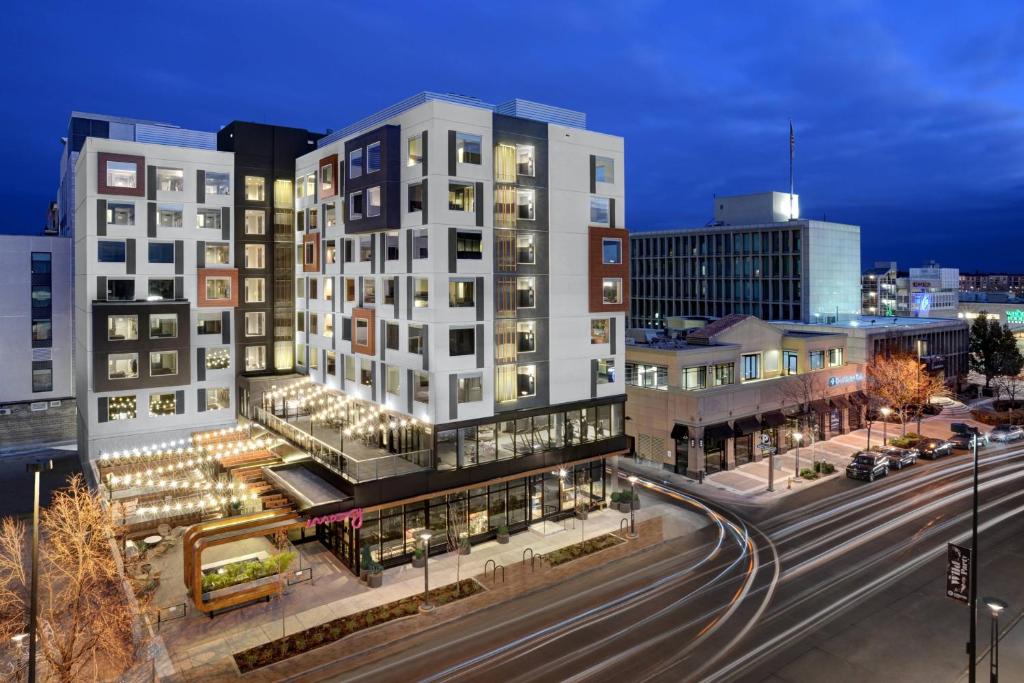a tall white building in a city at night at MOXY Denver Cherry Creek in Denver