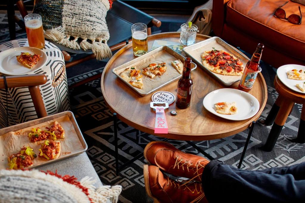a table with three trays of food and bottles of beer at MOXY Denver Cherry Creek in Denver