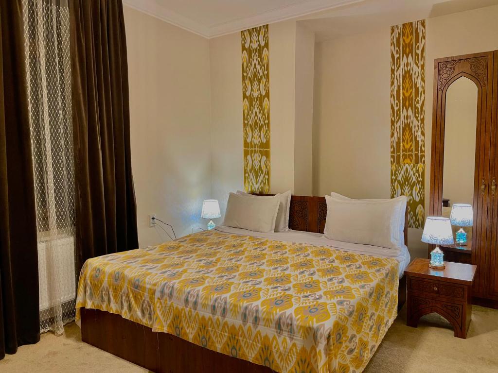 a bedroom with a large bed with a colorful bedspread at Hotel Saidkasim with a Terrace in Bukhara