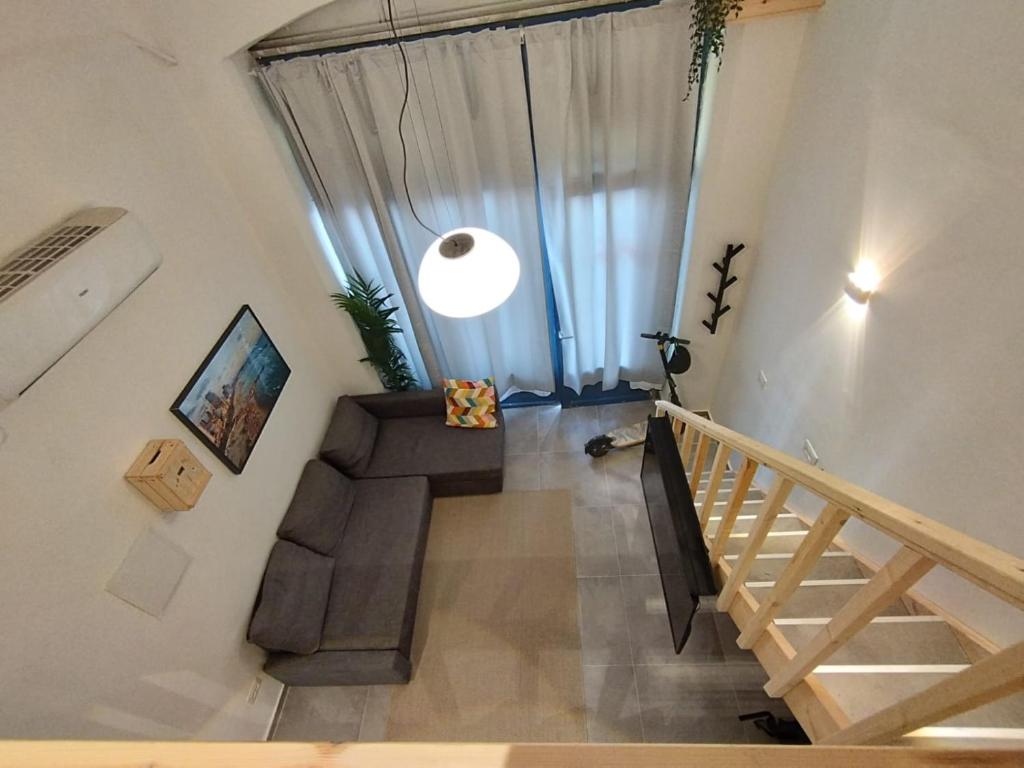Pokój z klatką schodową i oknem z kanapą w obiekcie U Sea Apartment -1# Location Next to Beach w Tel Awiwie