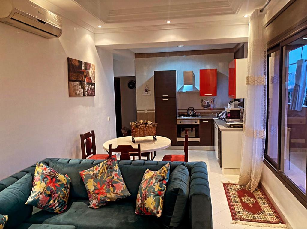 a living room with a blue couch and a kitchen at Nice apartment in the city center in Marrakech