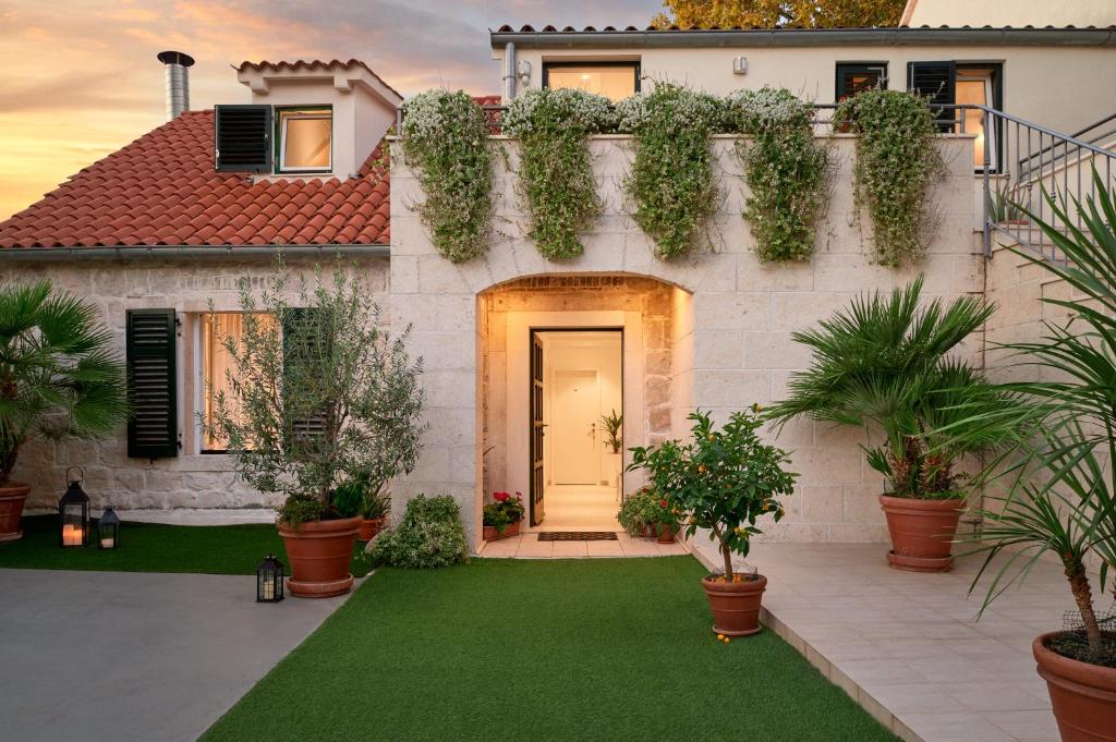 uma casa com um jardim verde com plantas em Lanterna Rooms em Split