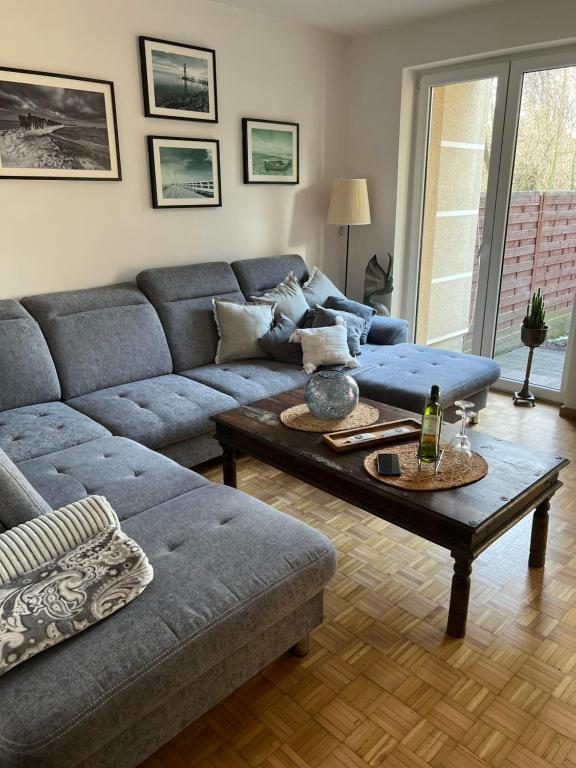 - un salon avec un canapé bleu et une table dans l'établissement Apartament Rumia 45, à Rumia