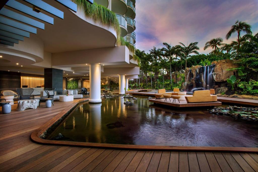 a hotel lobby with a pond in front of a waterfall at The Westin Maui Resort & Spa, Ka'anapali in Lahaina