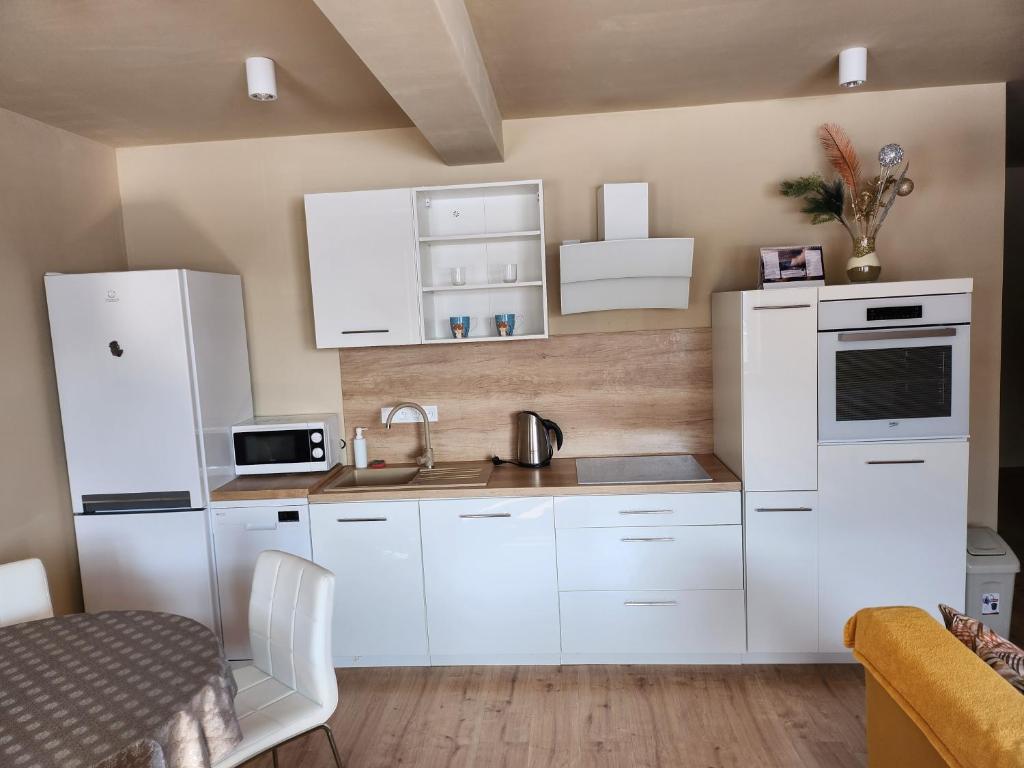 a kitchen with white cabinets and a sink at Apartmán Greenside in Michalovce