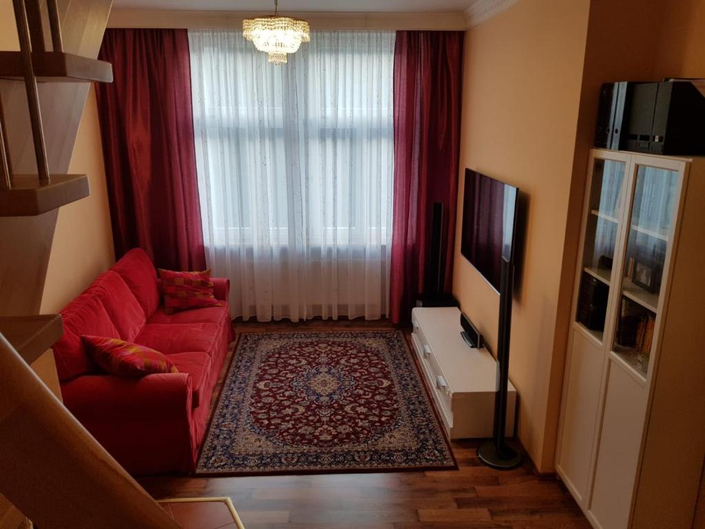 een woonkamer met een rode bank en een raam bij Apartman Moravska 188 in Karlsbad