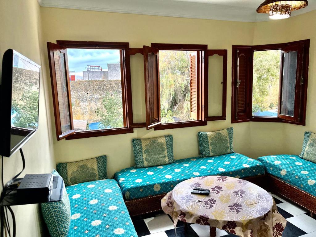 a room with chairs and a table and windows at soleado apartamento al lado de la preciosa medina , a 3 minutos de la playa andando I in Asilah