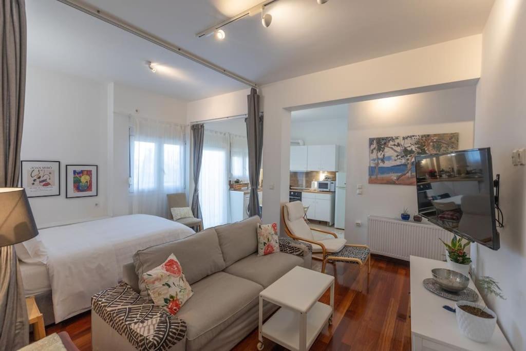 ein Wohnzimmer mit einem Sofa und einem Bett in der Unterkunft Λάρισα διαμέρισμα με θέα πλατεία στο κέντρο της πόλης in Larisa