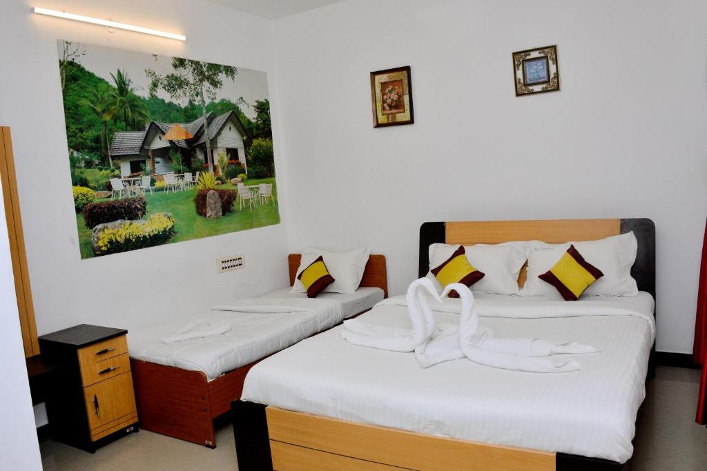 two beds in a room with a painting on the wall at TGT Holidays Yercaud in Yercaud