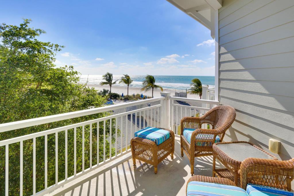 un balcón con sillas y mesas y la playa en Standard 2 Bedroom C, en Holmes Beach