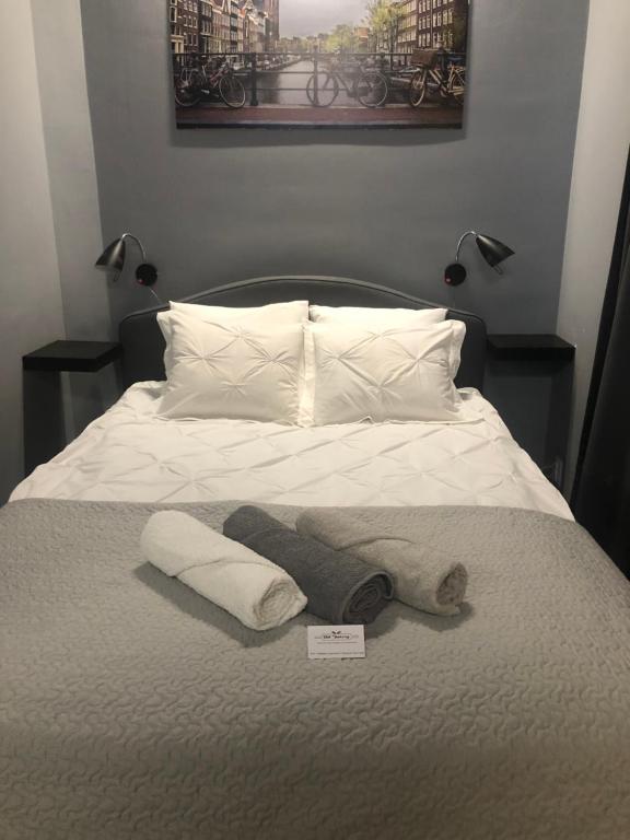 - un lit avec une couverture et des oreillers dans l'établissement Piekarnia Apartamenty Manufaktura parking dostep na kod 1-3 pokoje prywatna kamienica, à Łódź