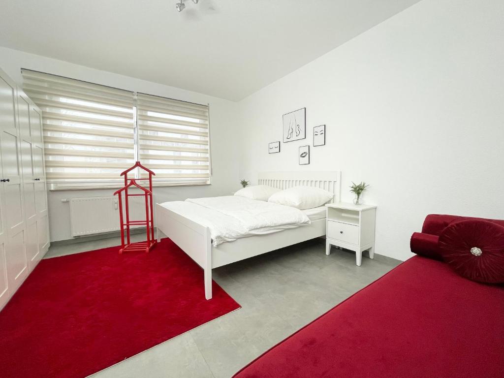 - une chambre avec un lit blanc et un tapis rouge dans l'établissement Wohnung in Kassel mit Ladesäulen, à Cassel